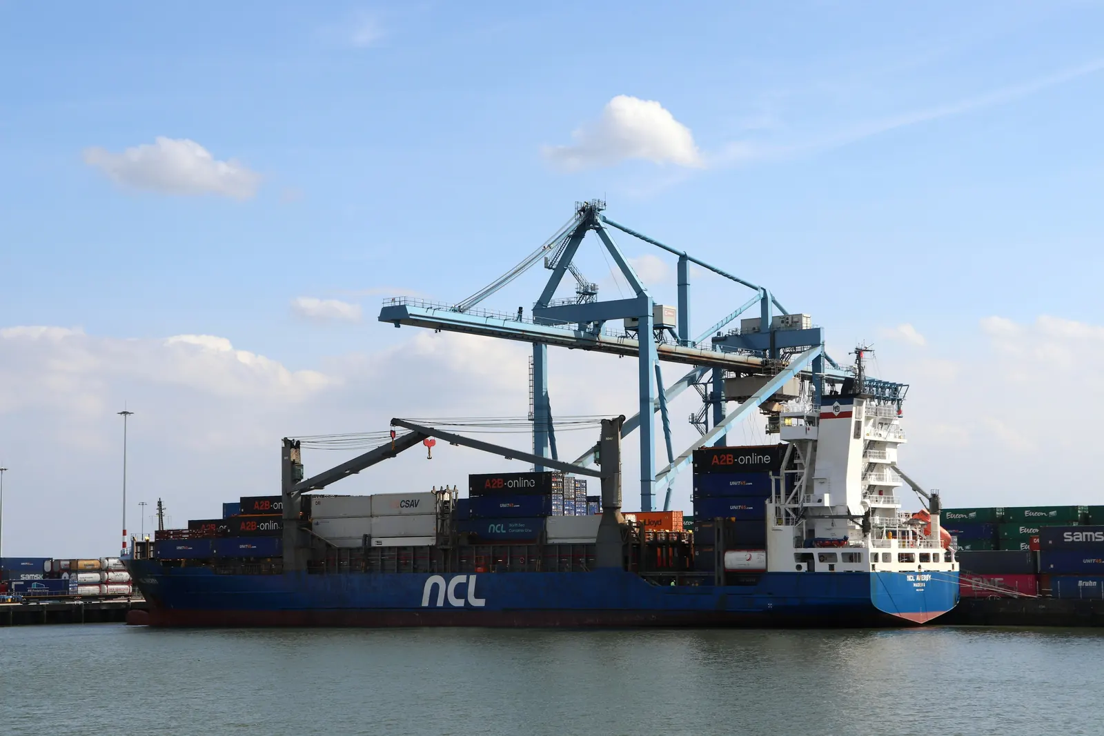 A container ship under gantry cranes at a terminal in the Port of Rotterdam